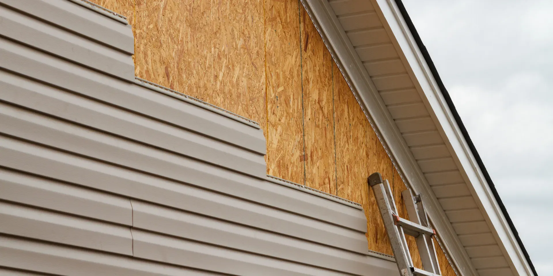 new siding being installed at peak of home