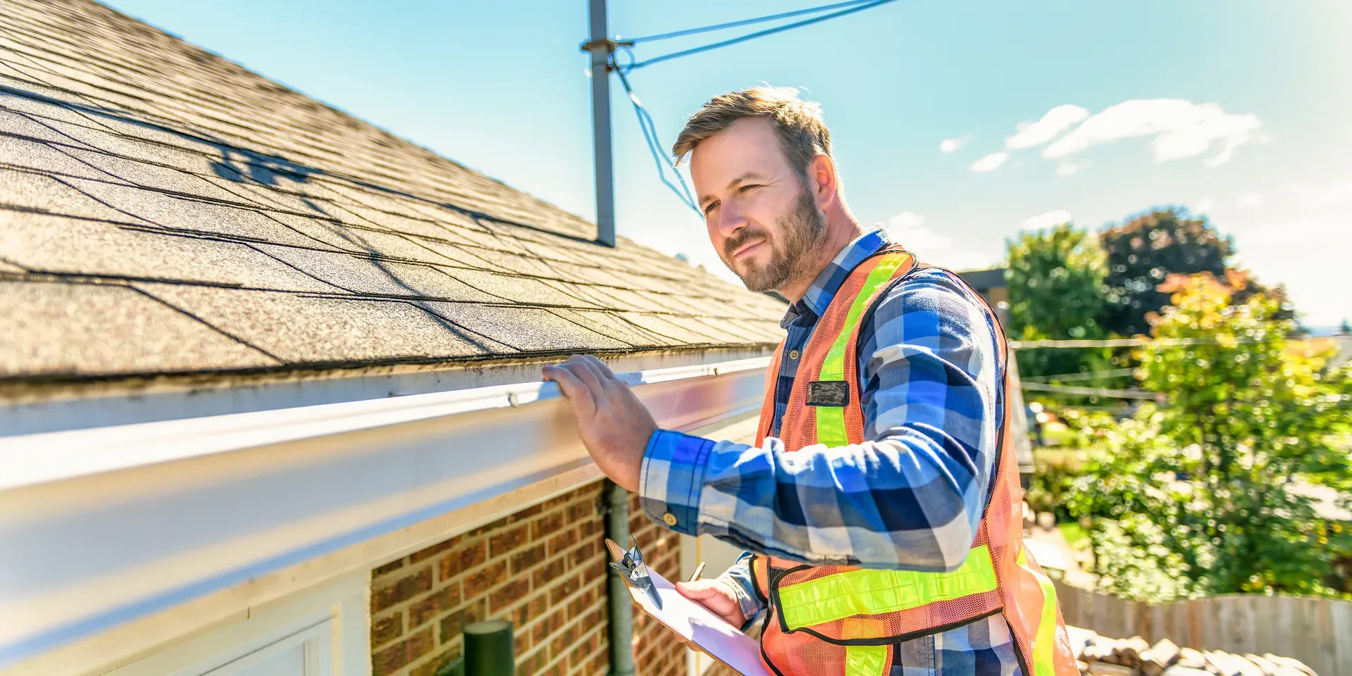 roof inspection being performed, looking over gutters and roof shingles